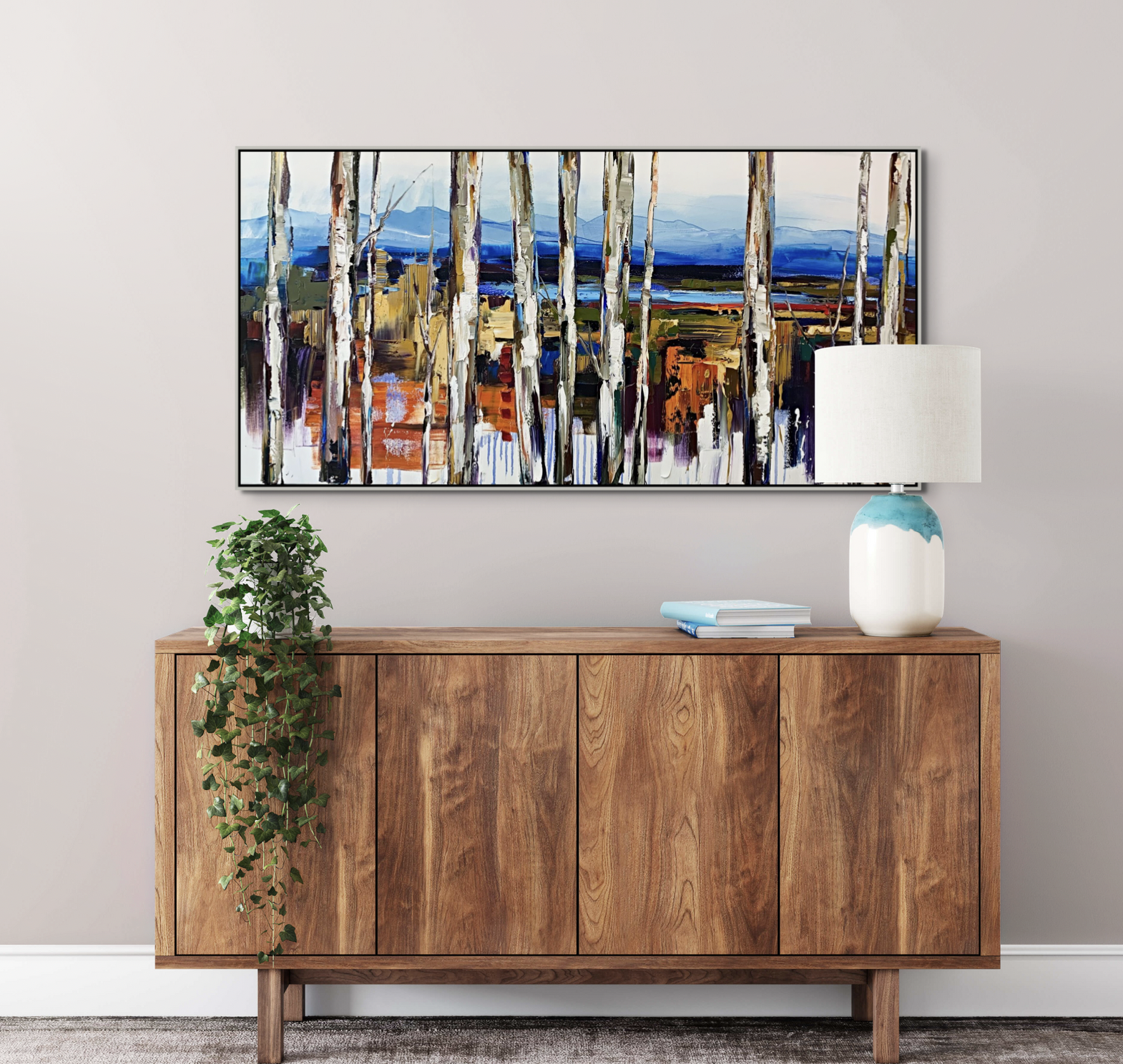 Kimberly Kiel oil painting of yellow and orange birch trees with mountains and wetlands in the foreground above a wooden mid-century modern cabinet.