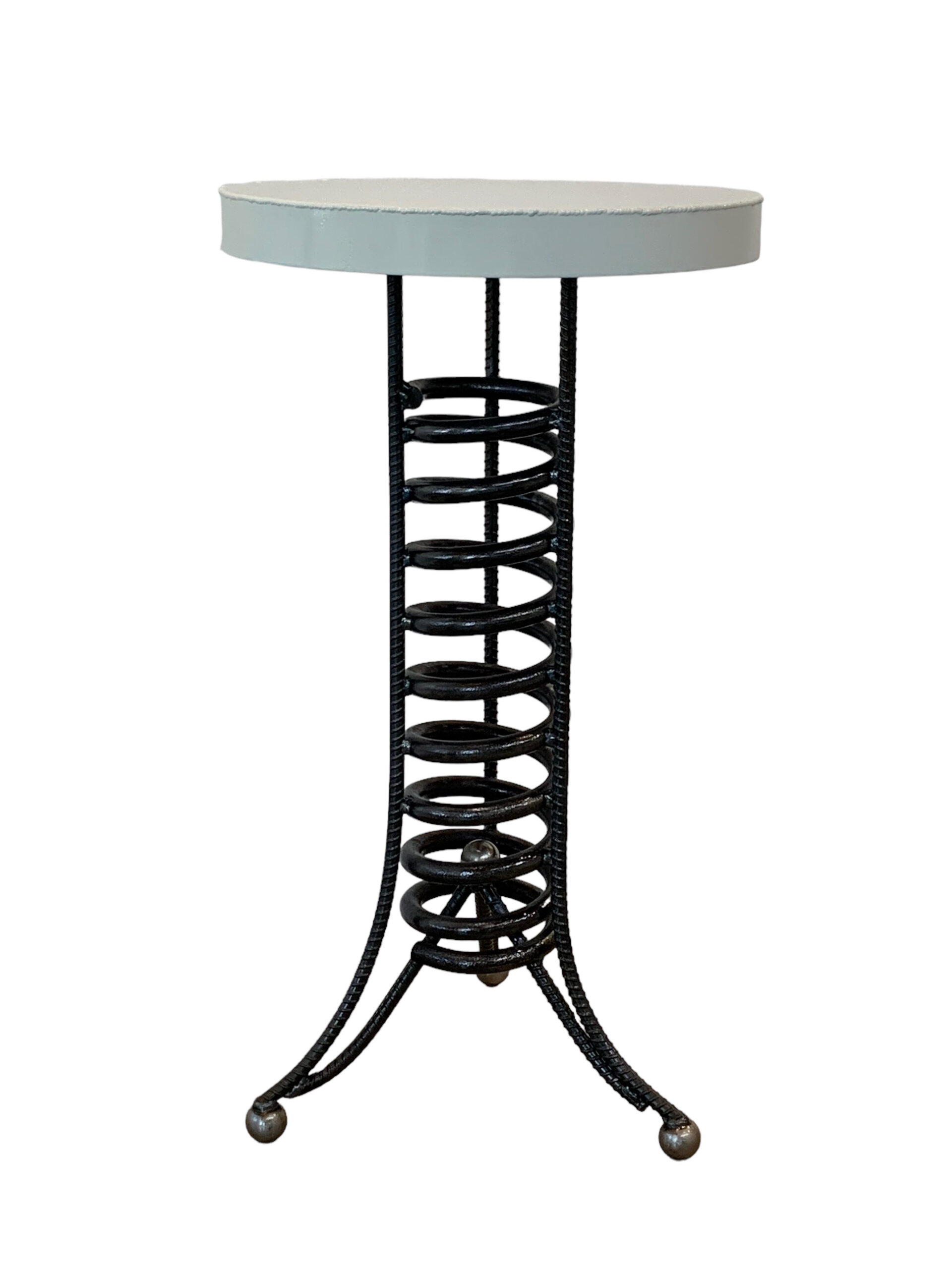 Reclaimed metal side table with a black spiral base and round cream top by artist Wendy Stone.