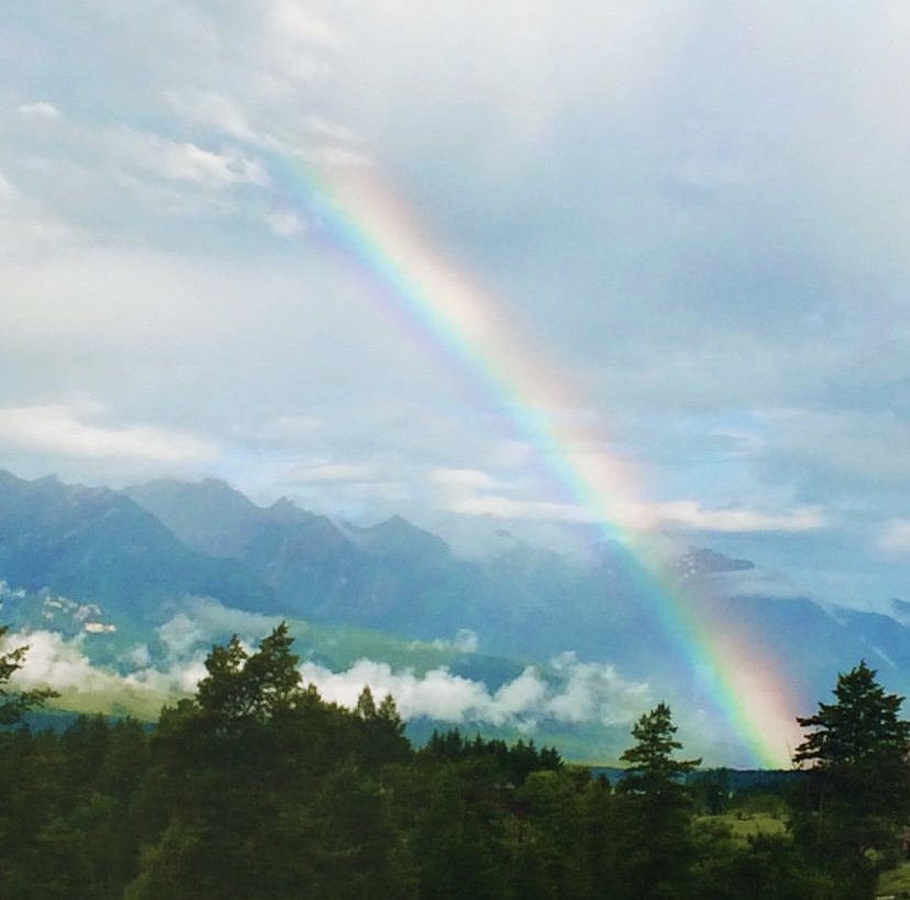 Photograph of a clearing storm and a bright rainbow over Lake Windermere by Erin Luyendyk.