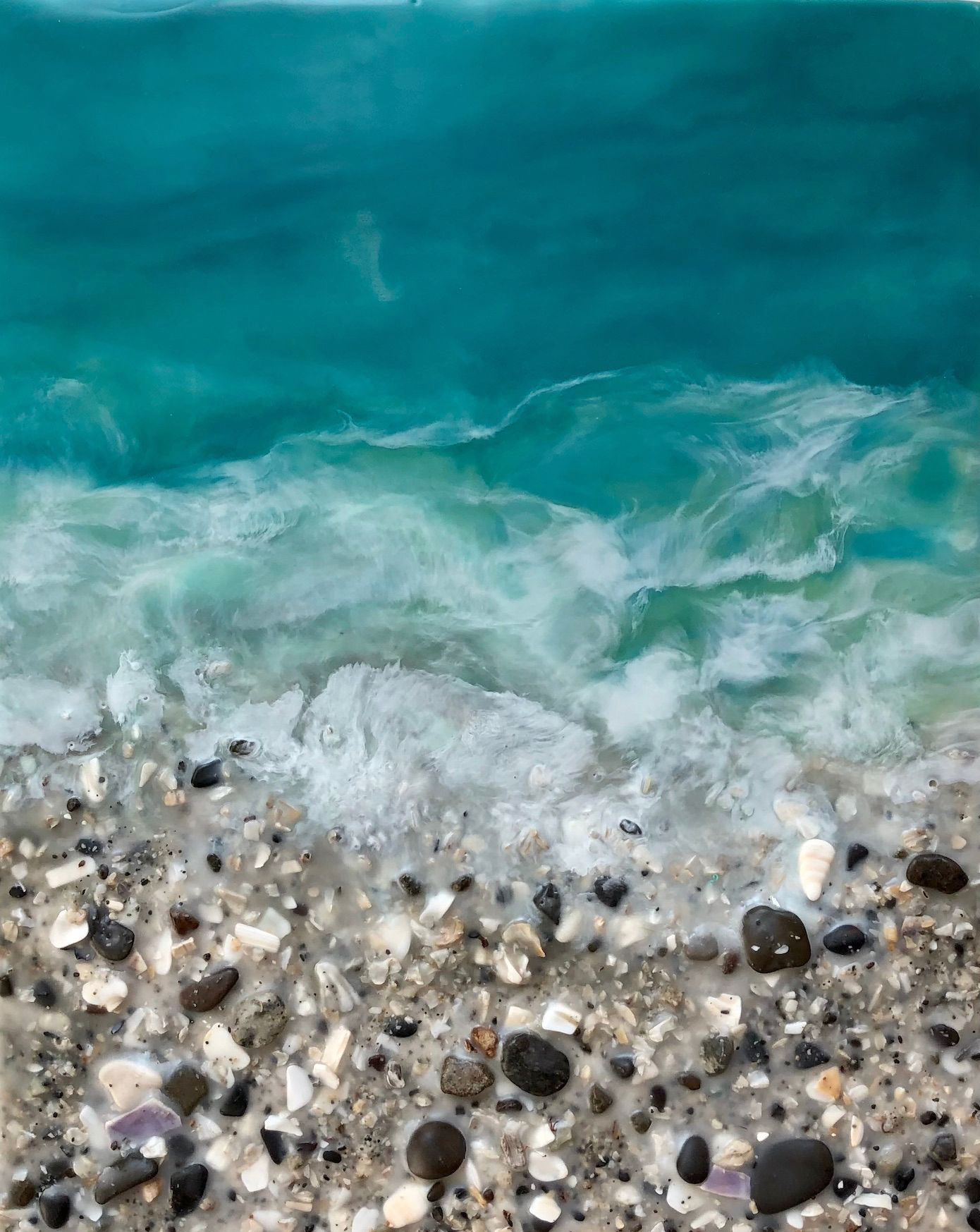 Original encaustic painting of a turquoise ocean with a real, textured sand, rock, and shell beach by Brenda Walker.
