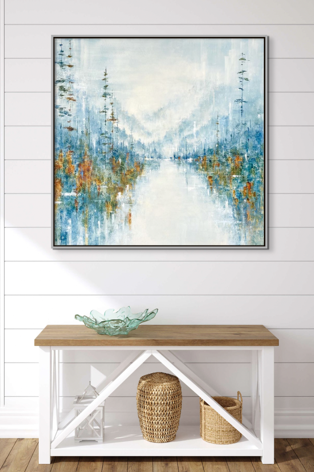 Soft abstract mountain lake landscape painting by Gina Sarro on a white shiplap wall over a small white and wood cabinet.